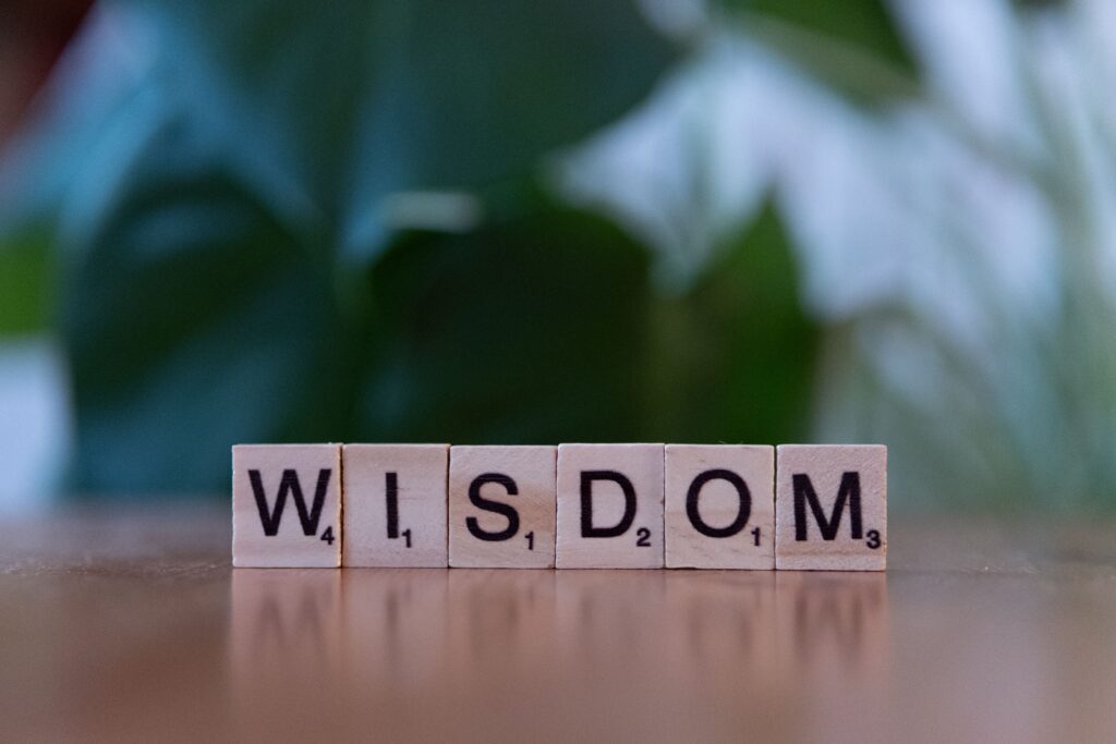 The word Wisdom spelled out with Scrabble tiles